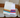 Two pairs of OUTWAY athletic crew socks with colourful stripe designs draped over a wooden chair arm