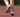 Runner on a track wearing OUTWAY athletic quarter socks with colourful dinosaur pattern