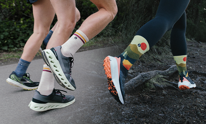 Two runners on road and trail wearing OUTWAY crew socks, one in white retro stripe design and one in a colourful nature print, shown from the knees down mid-stride.